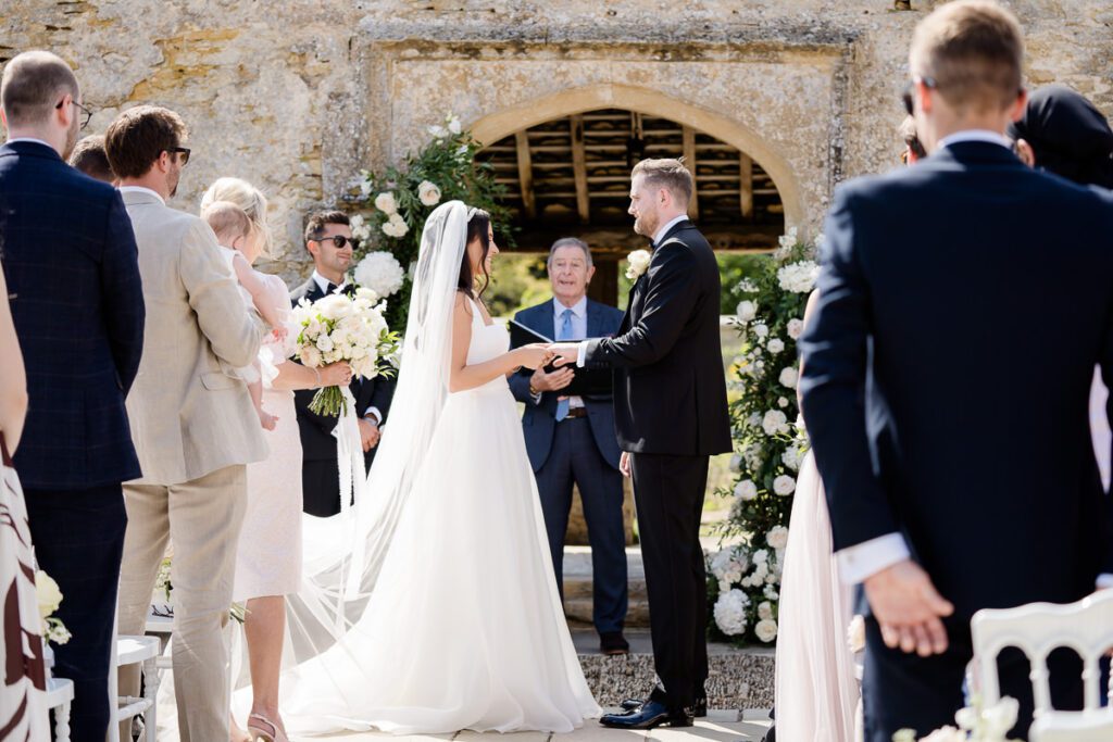 a bride and groom exchange rings in the wedding ceremony at Caswell House