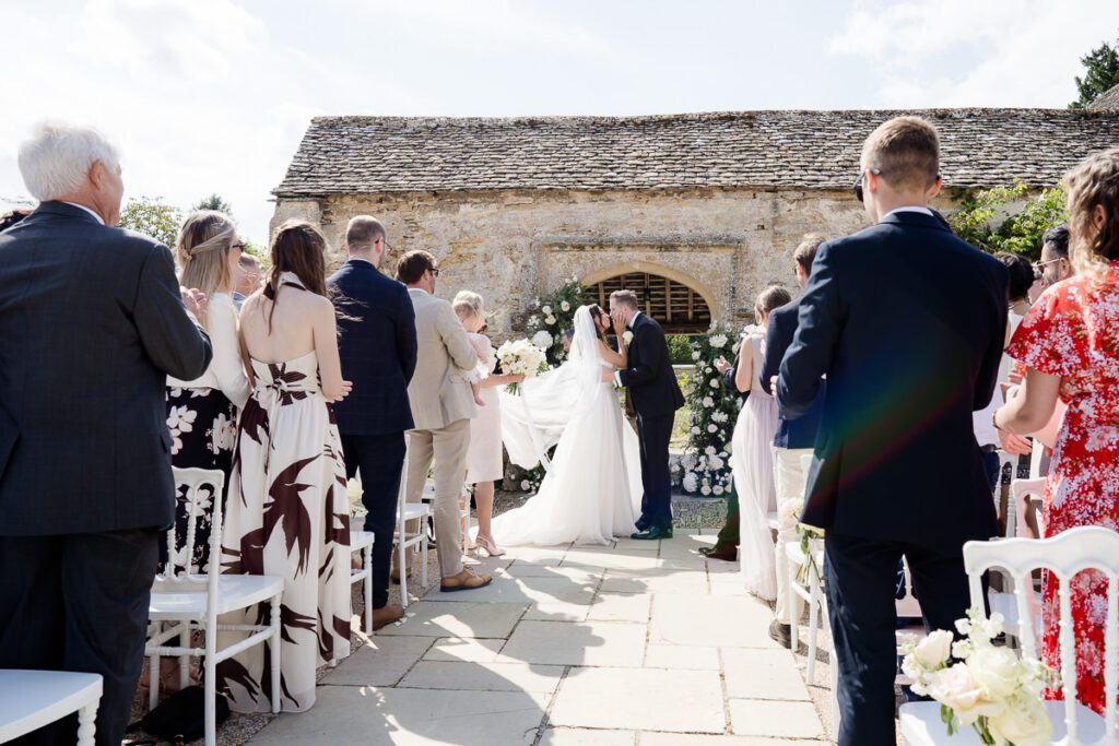 a bride and groom share their first kiss in their outdoor ceremony at Caswell House