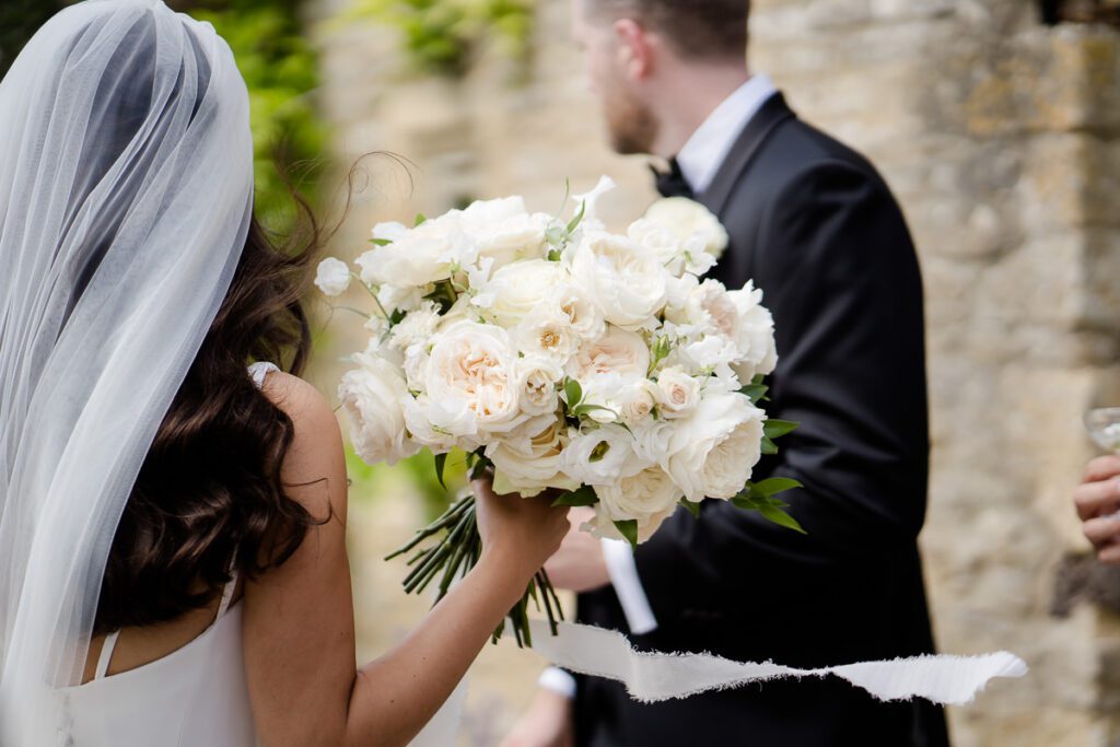 bride holding her bouquet made up of white roses at Caswell House wedding venue Oxfordshire