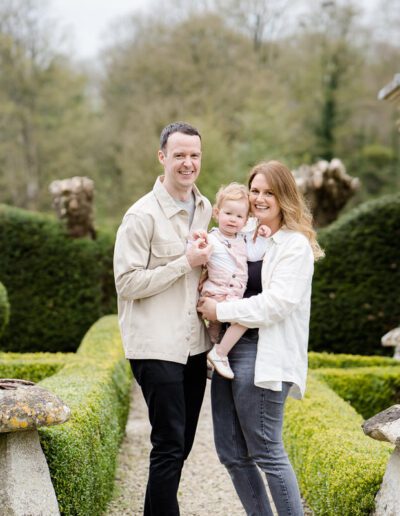 a mum and dad hold their baby girl between them during a family photo shoot by Lydia Stamps Photography in Wiltshire