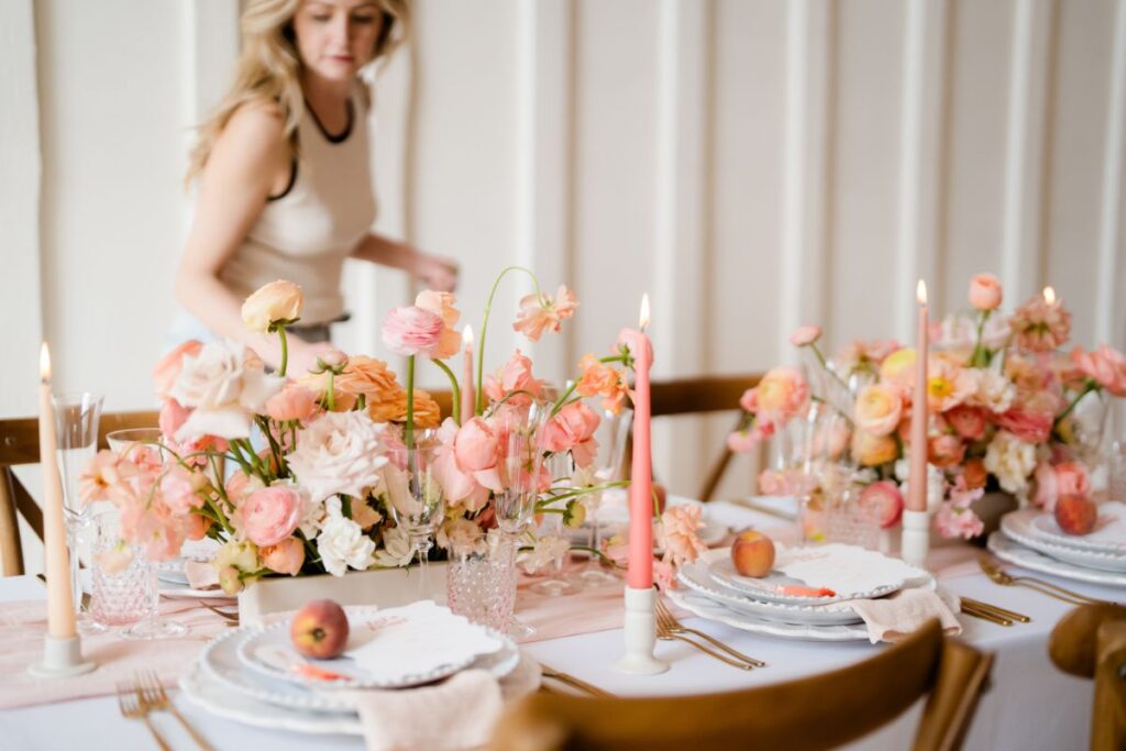 a florist checking a table scape at Millbridge Court wedding venue in Farnham Surrey phot by Lydia Stamps Photography